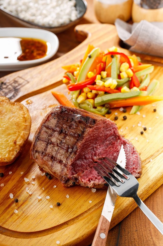 Pièce de viande grillée et légumes sur planche