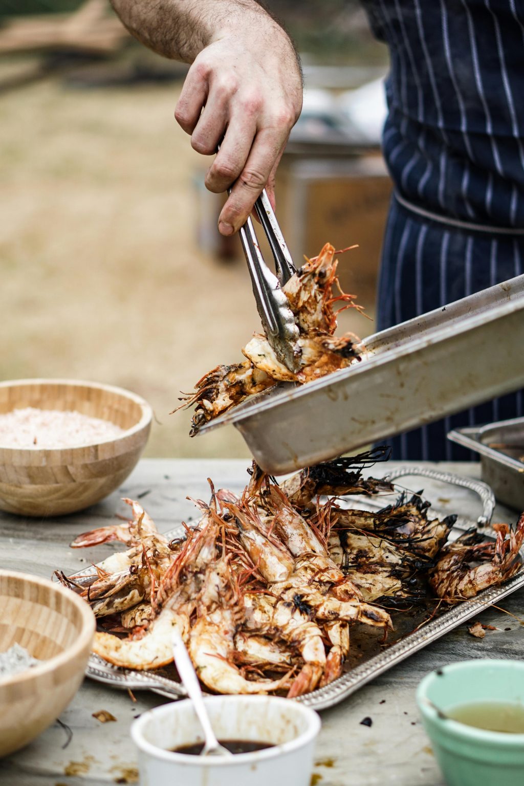Cuisinier dressant des crevettes grillées